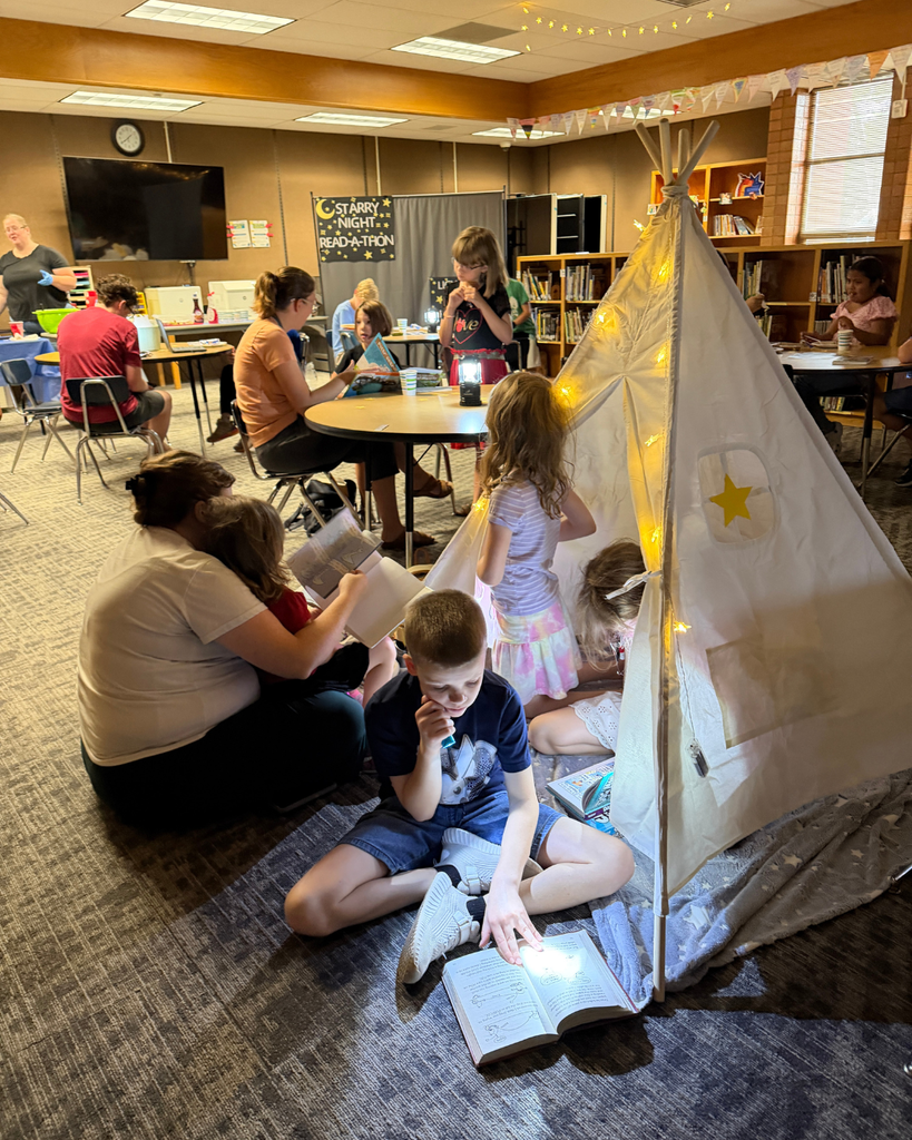 Parents and students reading under tents and twinkle lights indoors.