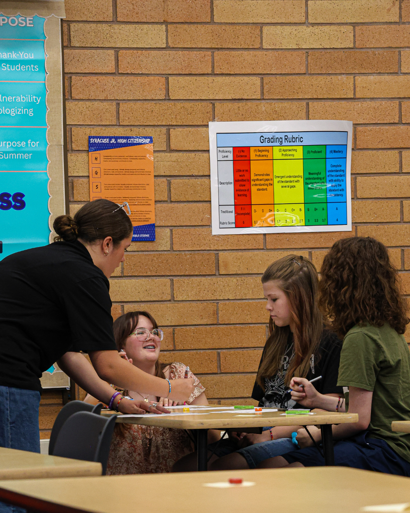 Four students working together while writing on papers.
