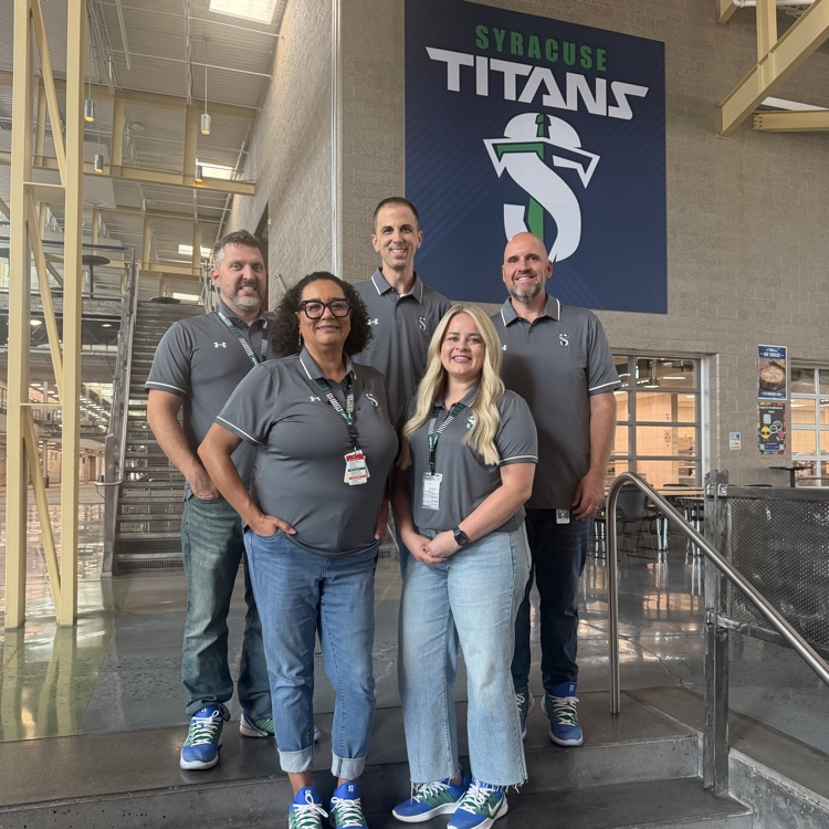 5 members of the administration team in grey polos, jeans and blue/green Nikes 