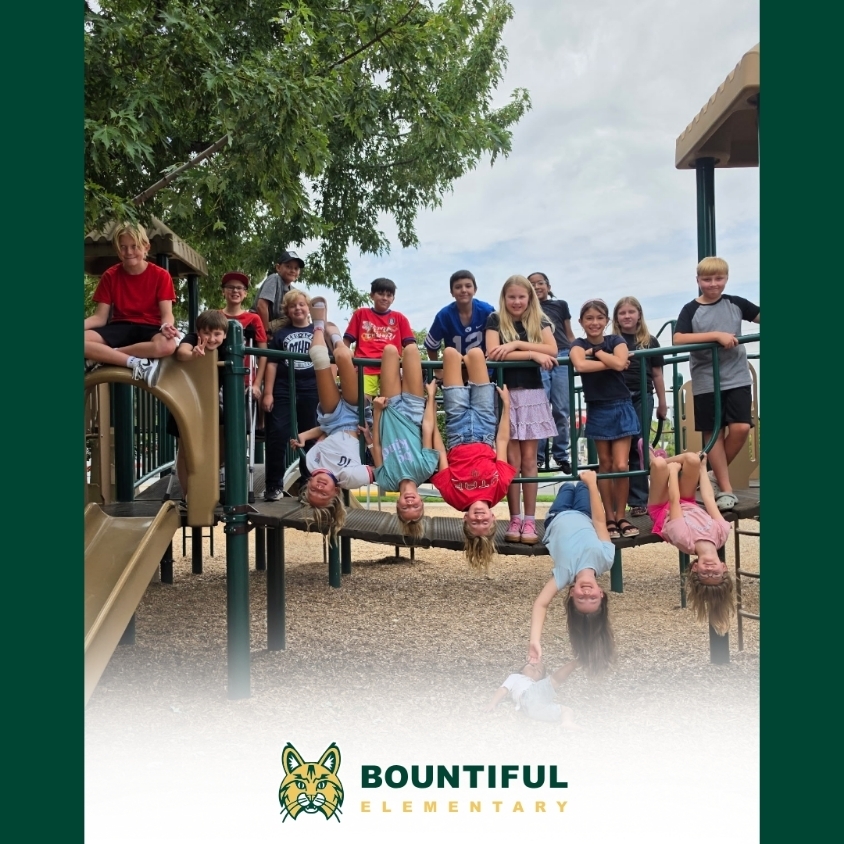 Members of Bountiful Elementary’s Hope Squad pose together on the school playground, with several students playfully hanging upside down from the playground equipment.