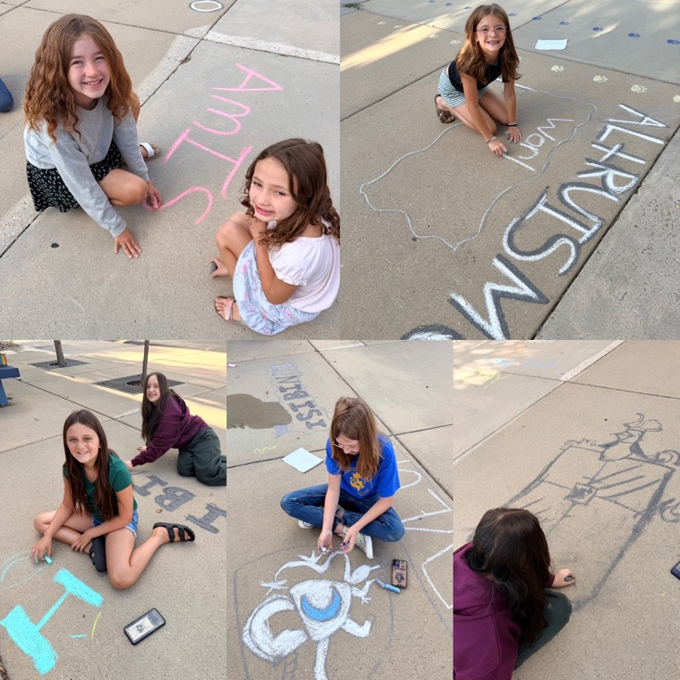 student leaders using chalk to decorate sidewalk for back to school night 