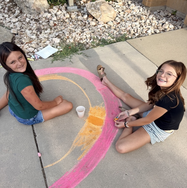 student leaders using chalk to decorate sidewalk for back to school night 