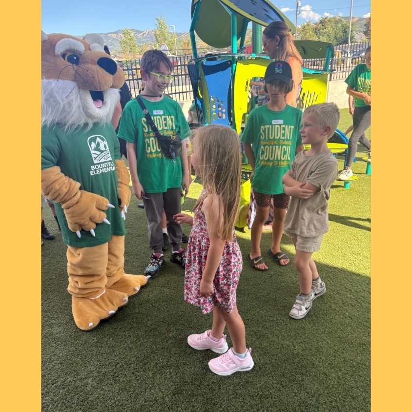 The Bountiful Elementary Bobcat mascot and two Student Council members visit with younger students on the playground during Back to School Night.
