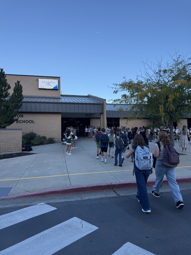 Students walking into school on the first day, greeted by cheerleaders, SBOs, and dance company.
