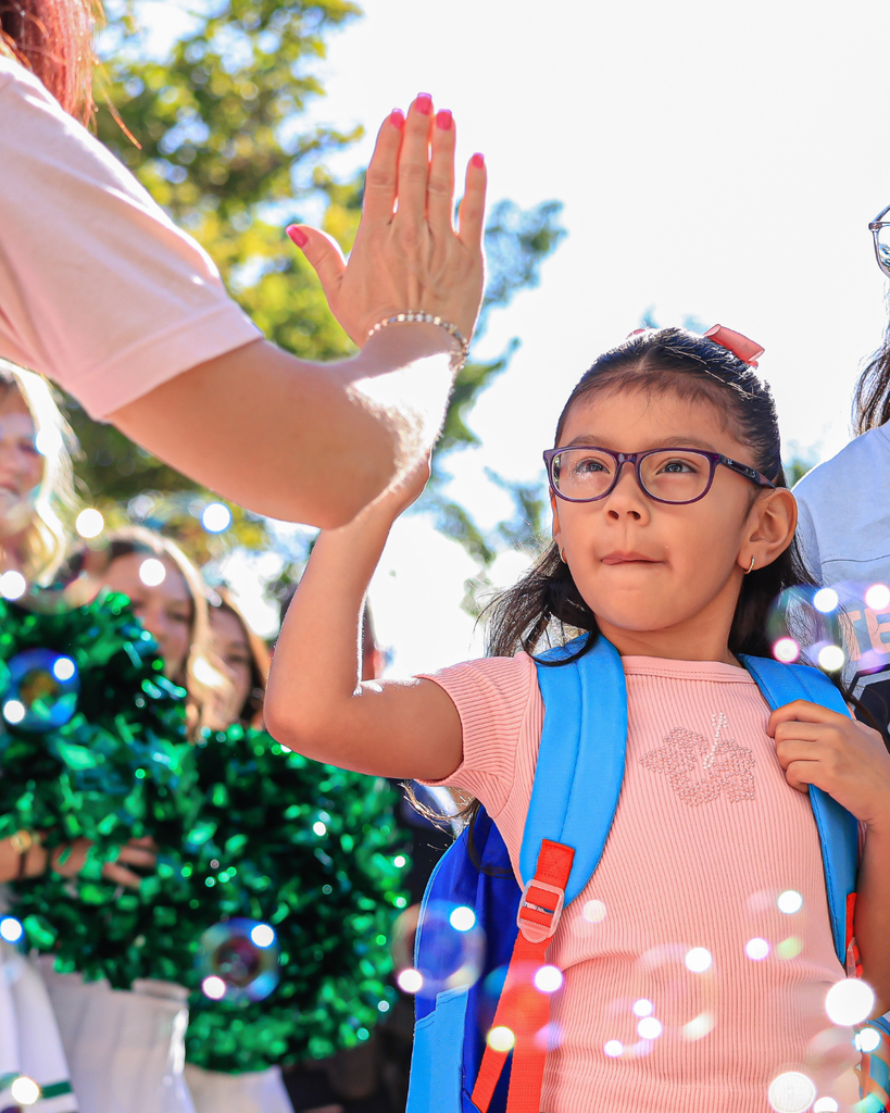A student high-fiving the principal.