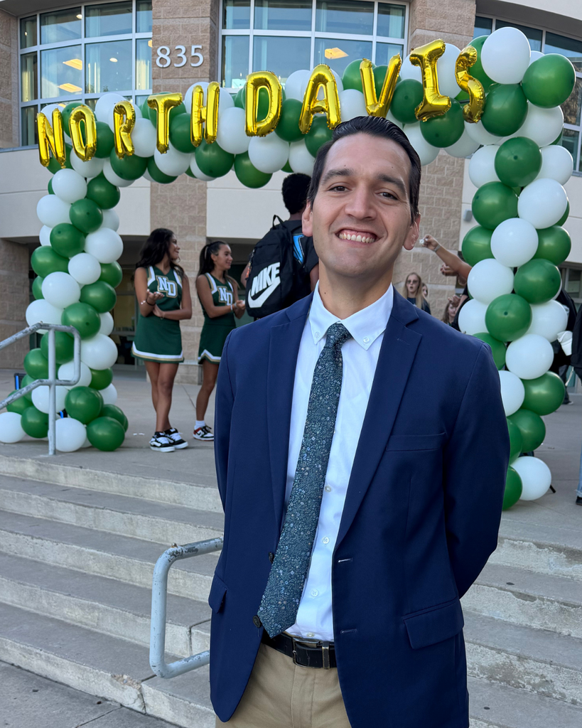 A principal smiling with "north davis" behind them.