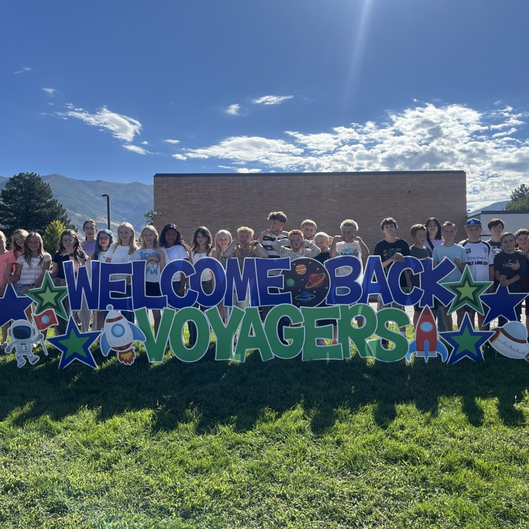 Students standing in front of a welcome back sign  