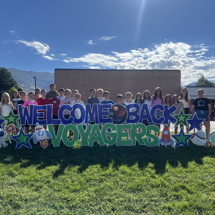 Students standing in front of a welcome back sign  