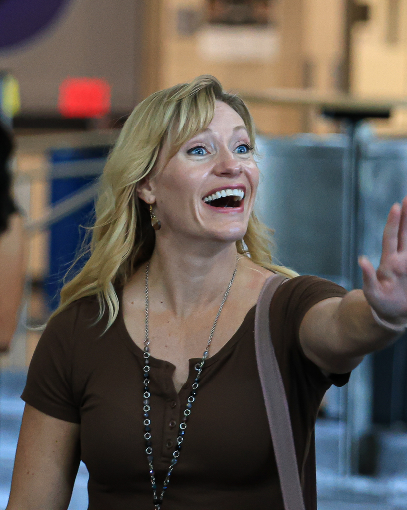 A teacher excitedly waves at someone.