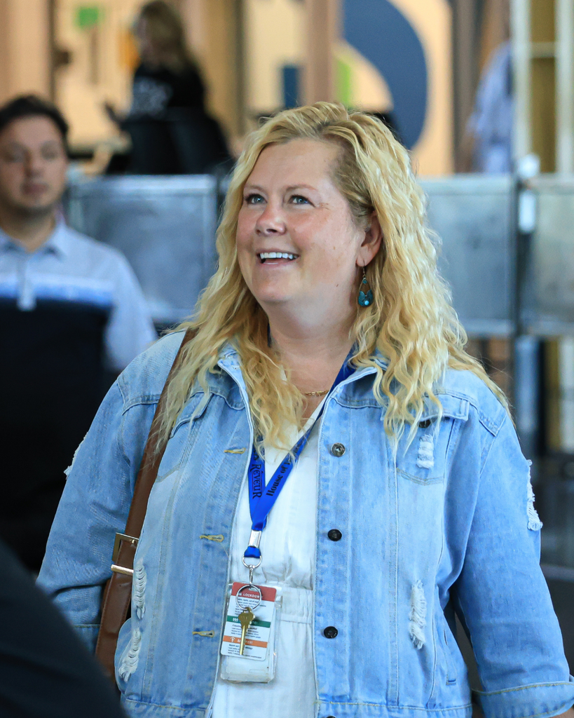 A teacher smiles as they walk down the hall.