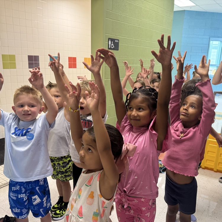 students raising hands in the hallway