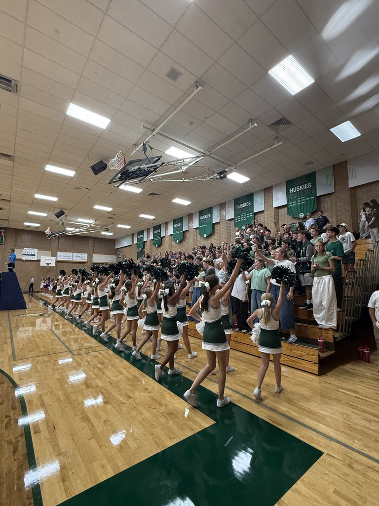 Fans cheering on the volleyball team with the cheerleaders. 