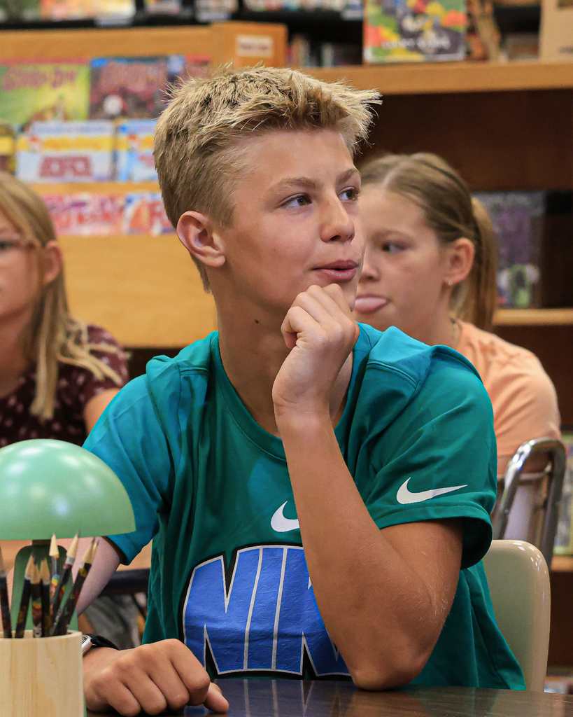 A student with their hand on their chin looking curious.