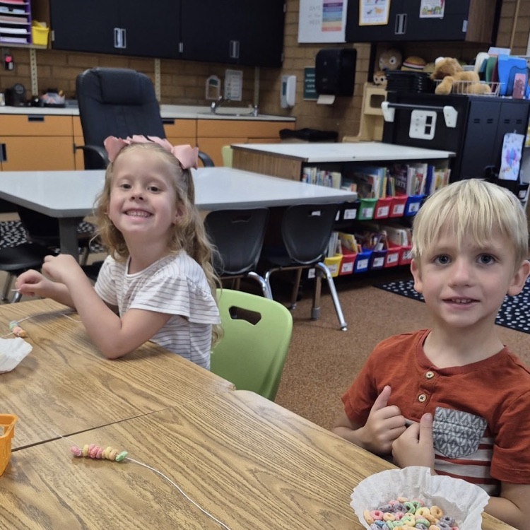 kindergarten making froot loop necklaces while learning about sorting and patterns 