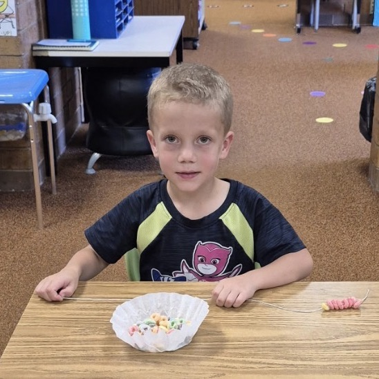 kindergarten making froot loop necklaces while learning about sorting and patterns 
