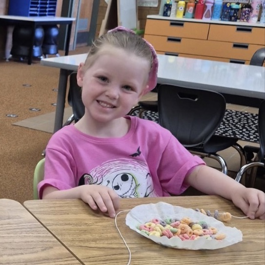 kindergarten making froot loop necklaces while learning about sorting and patterns 