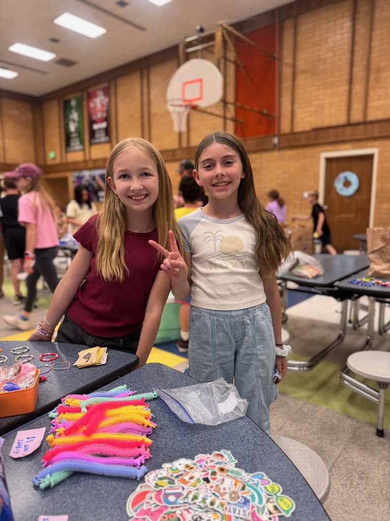 Two 4th grade girls in their cafeteria for their trading post
