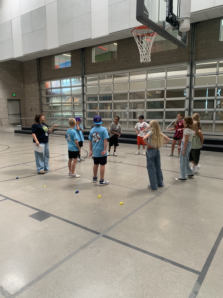 students standing in a circle while women talks to them