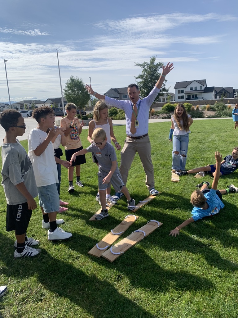 students cheering and laying on ground with wood planks in the middle
