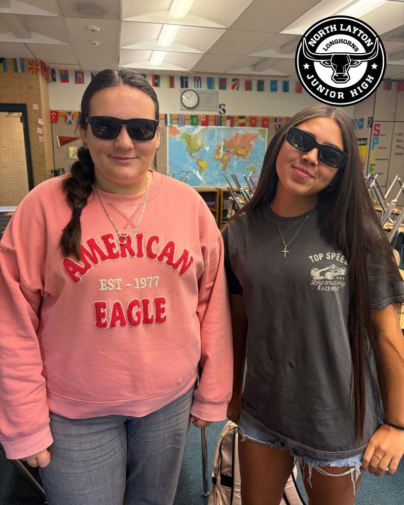 Two students stand wearing black sunglasses