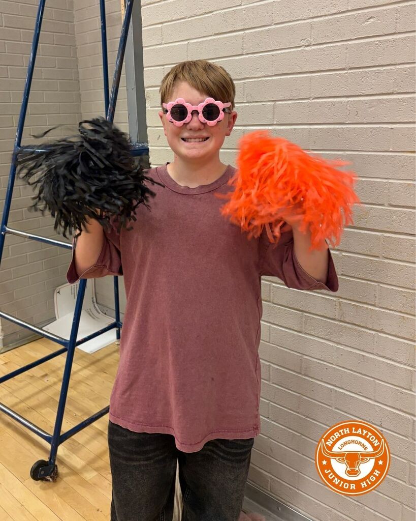 A student is cheering on the volleyball team wearing flower sunglasses