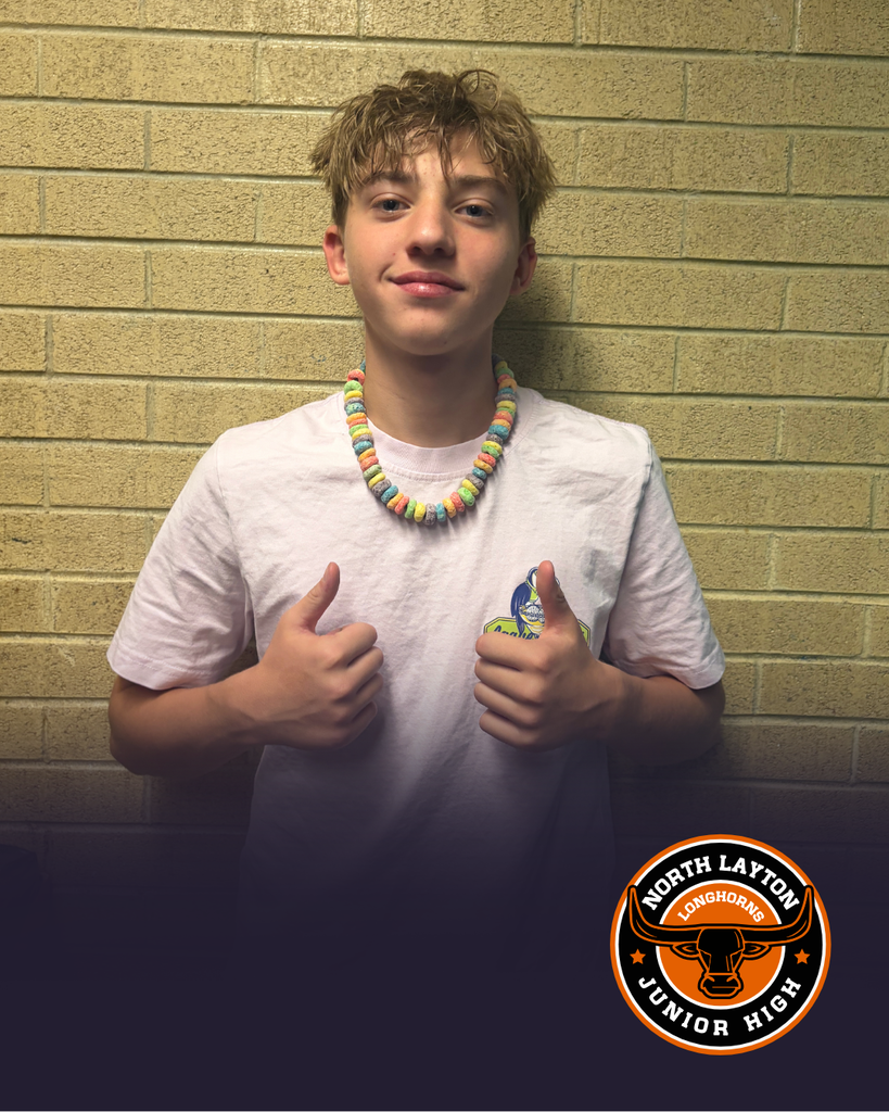 A student showing off a cereal necklace he made in child development
