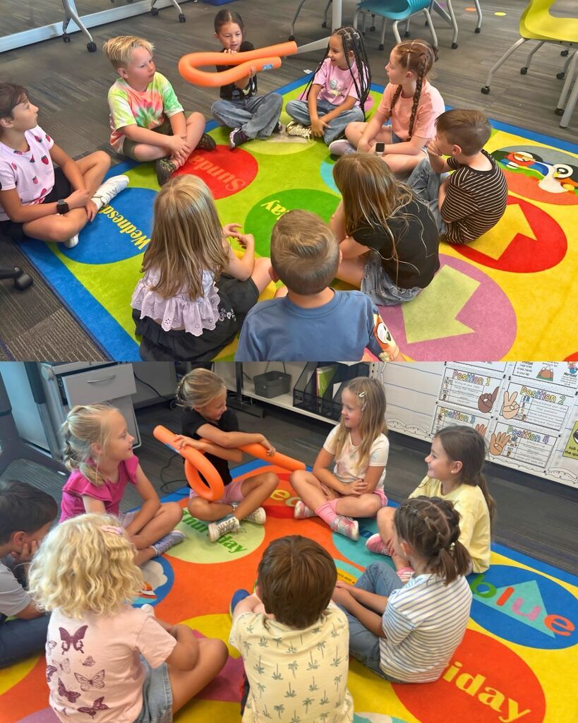 Students sit together on the classroom rug during a group learning activity.