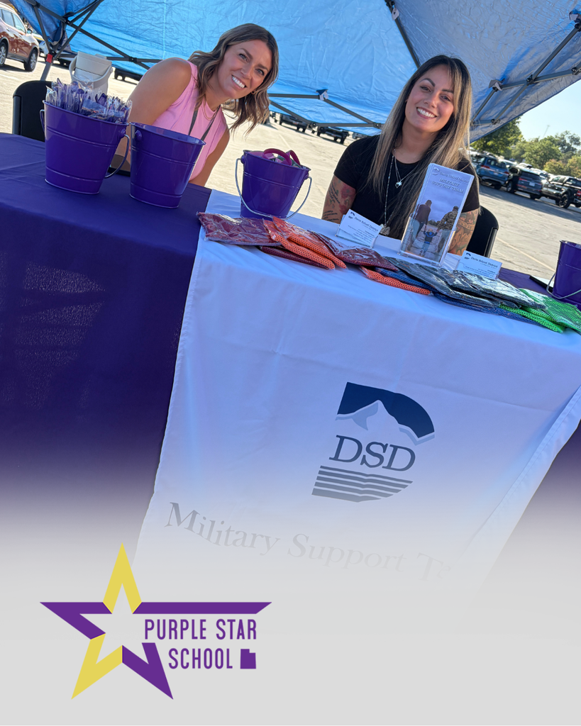 Our Military Support Team sitting at a booth during a community event to rise awareness about our Purple Start Schools