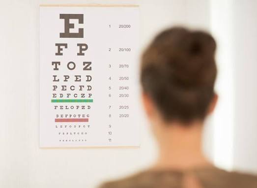 Girl standing in front of vision screening letter board