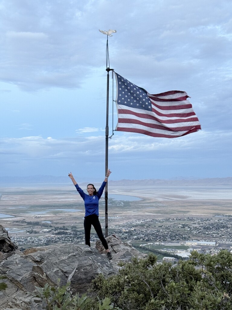 Picture of Officer Behm at the top of Flag Rock in Farmington. In remembrance of those who lost their lives on 9/11.