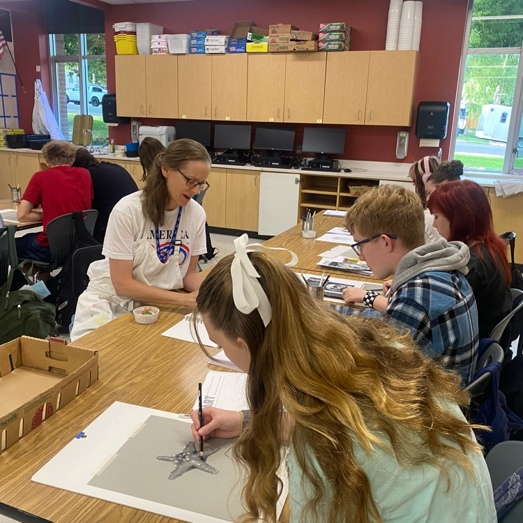teacher providing feedback to student about art