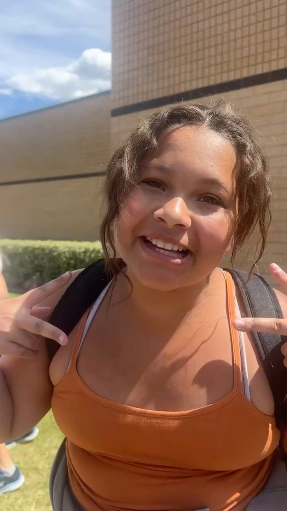 6th grade student cheering in front of her school