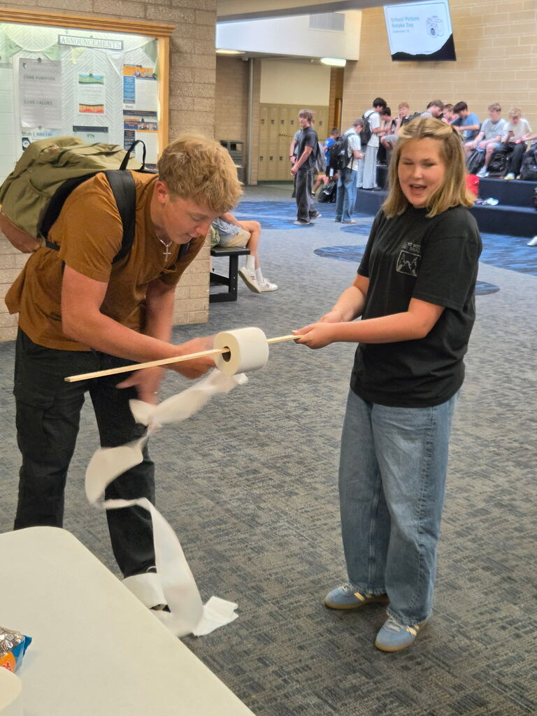 Student unrolling toilet paper for an activity. 