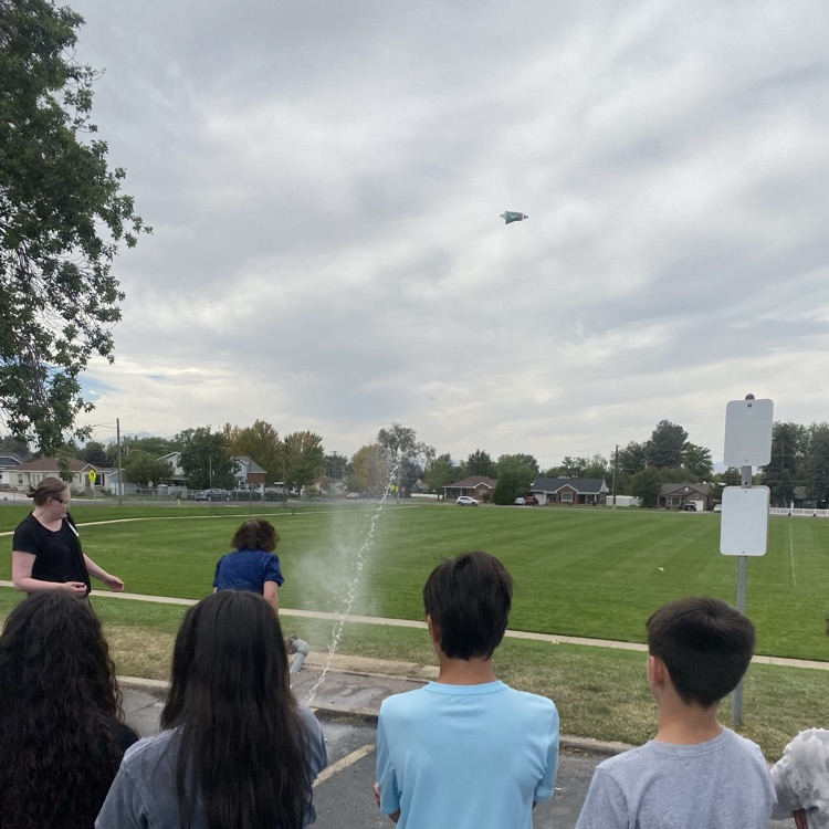 students watching rocket in flight