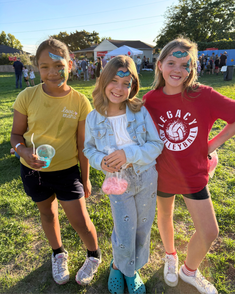 kids show off face paint at a carnival