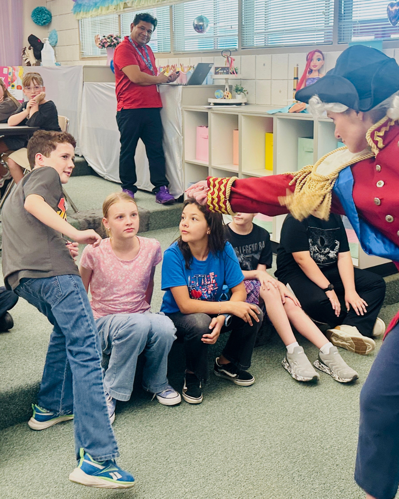 A student looks startled as a principal is dressed up.