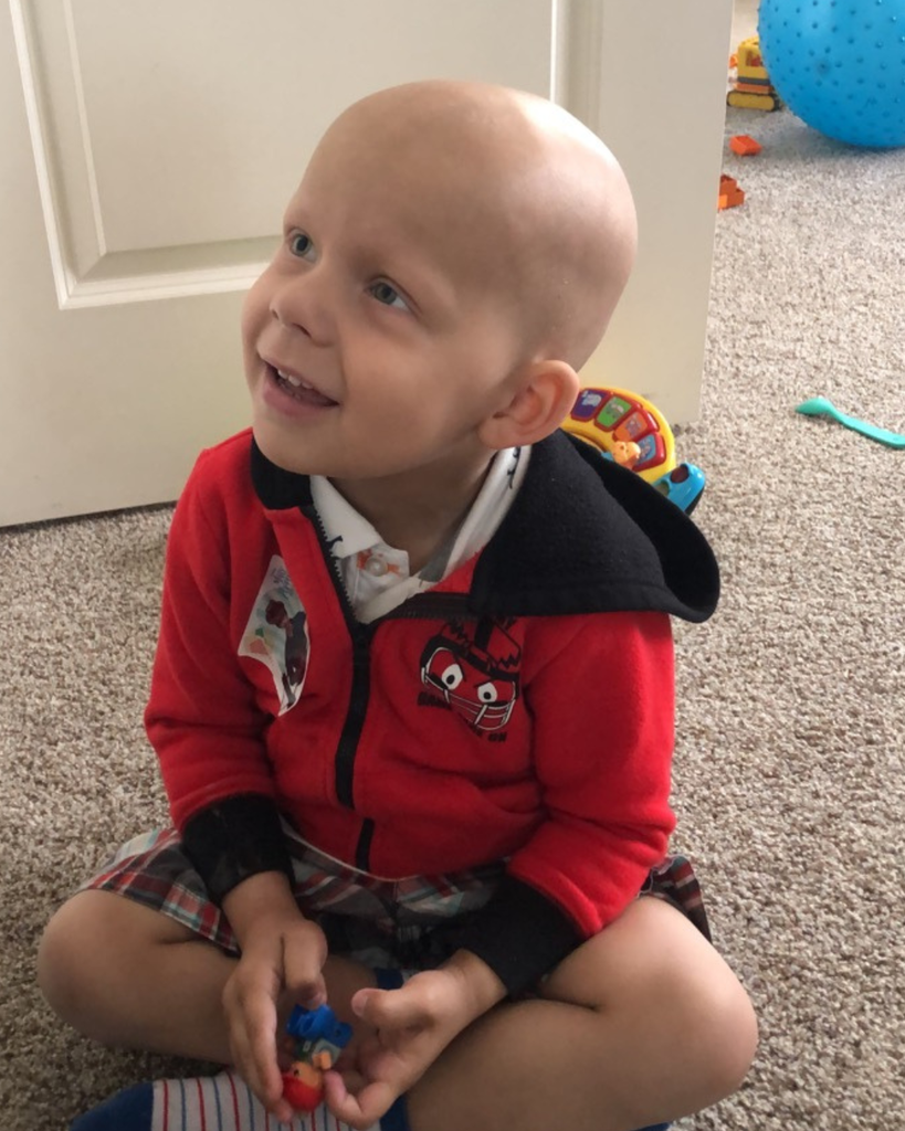 A student sitting on the floor smiling.