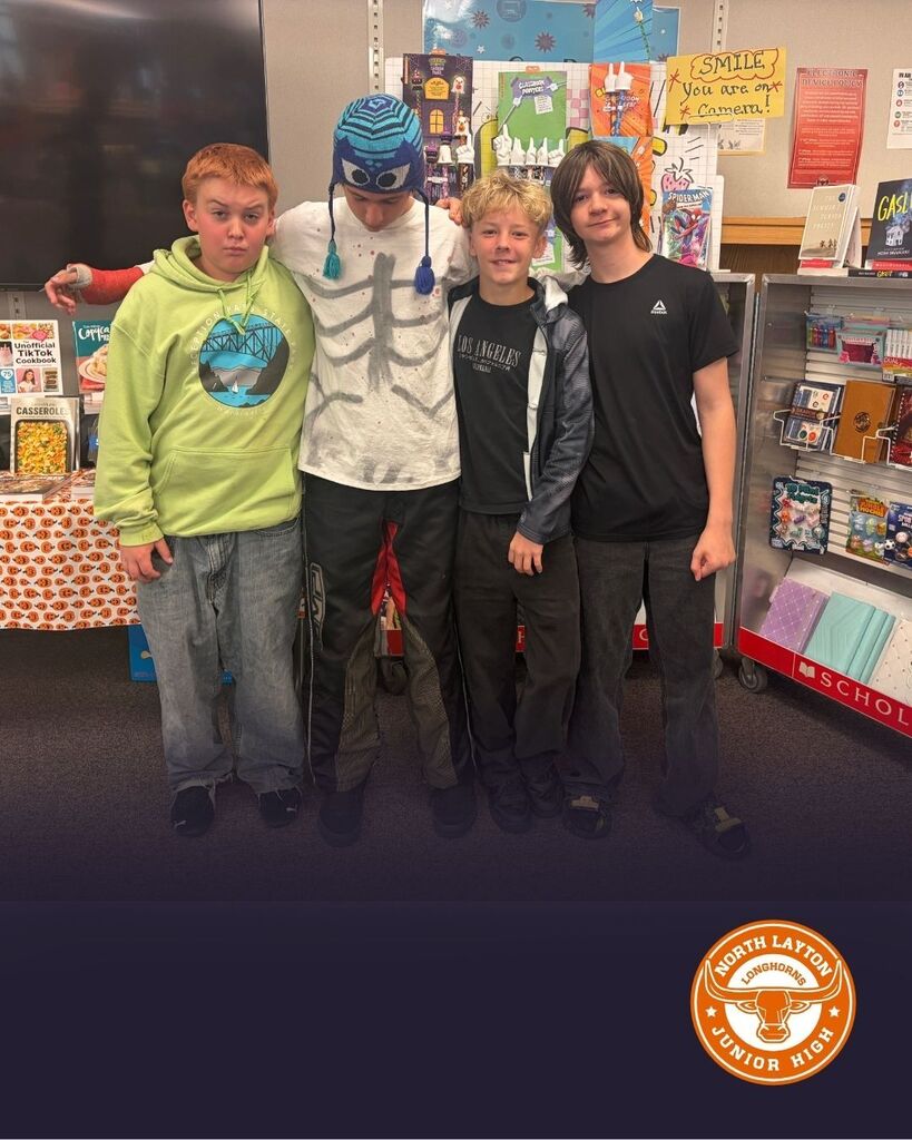 Students stand looking at books during the book fair at North Layton Jr.