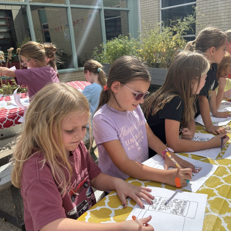 students sitting at a table coloring seat packets