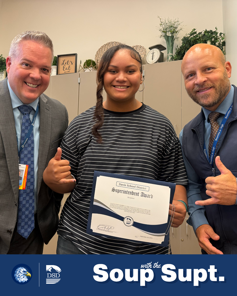A student smiling with their principal and the superintendent during Soup with the Supt. 