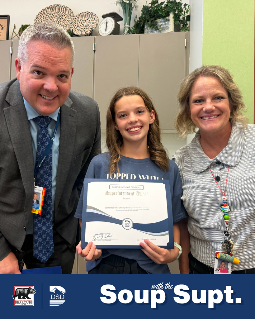 A student smiling with their principal and the superintendent during Soup with the Supt. 