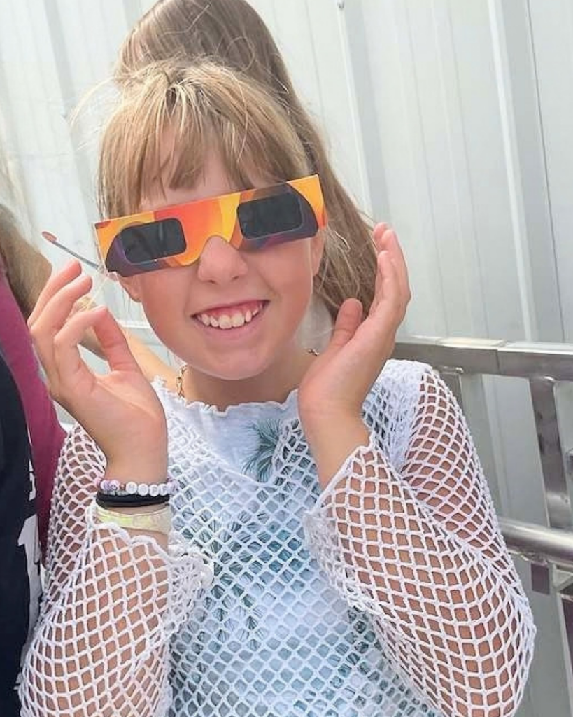 student wears eclipse glasses