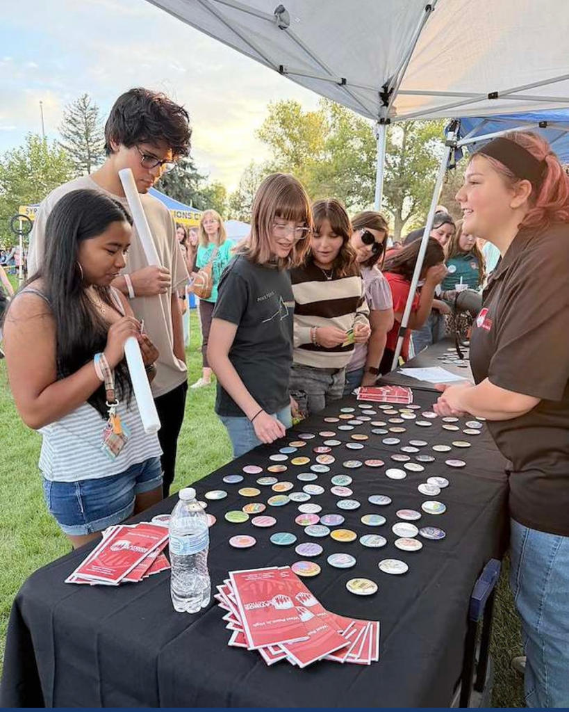 Students talking with other students at a booth.