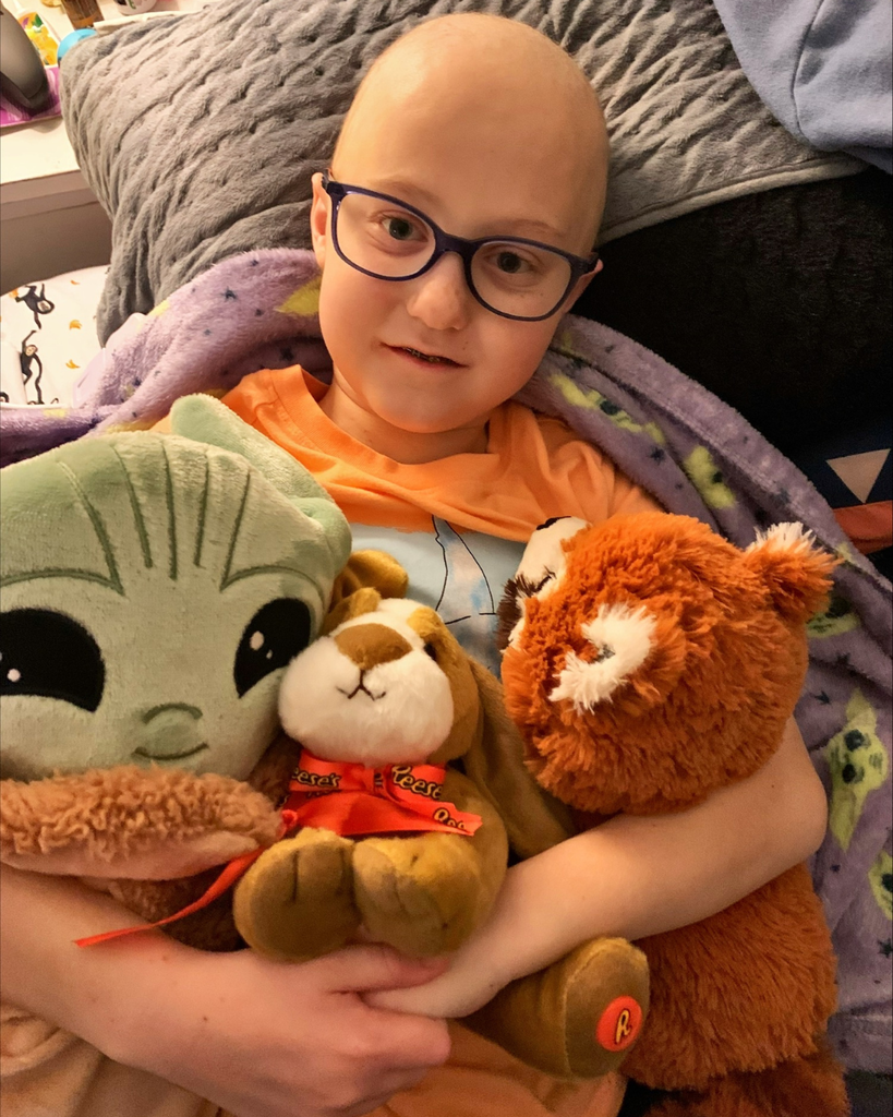 A student hugging stuffed animals.
