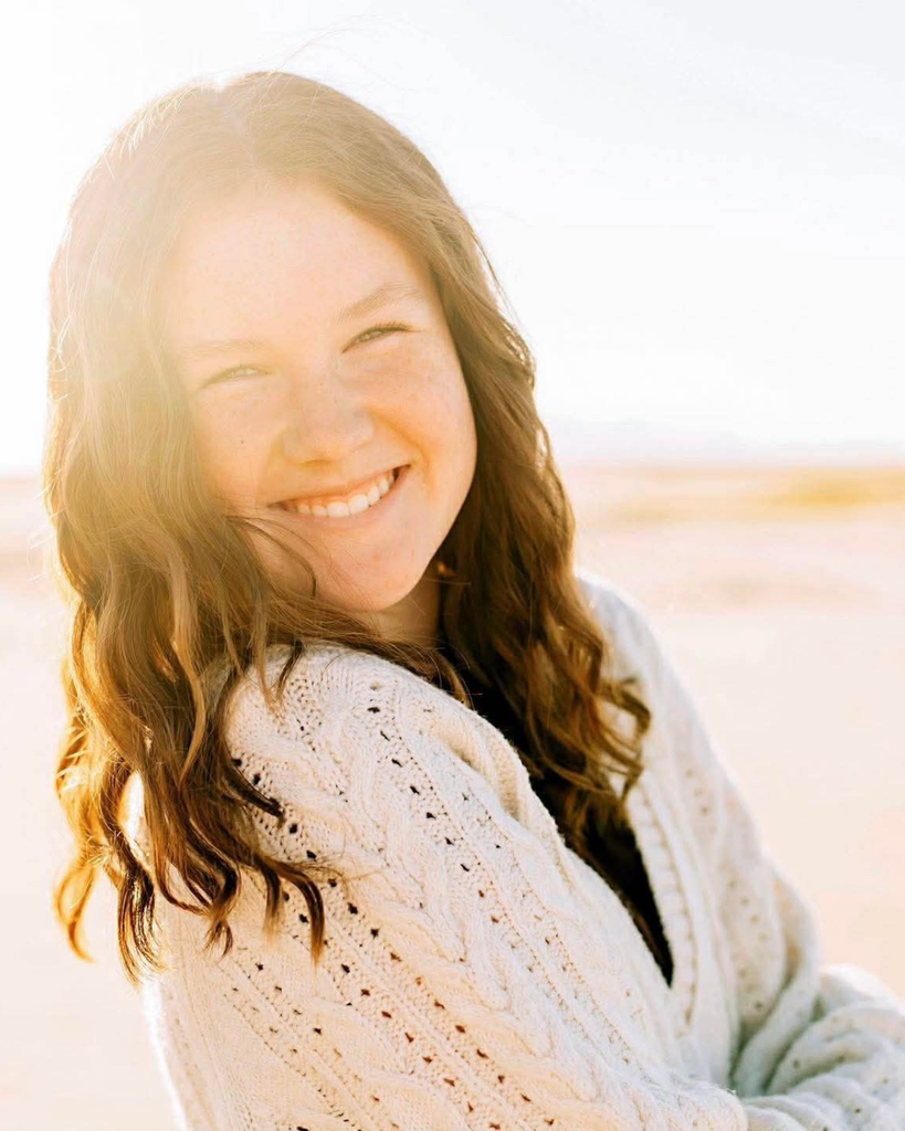 A student smiling in the sun. 