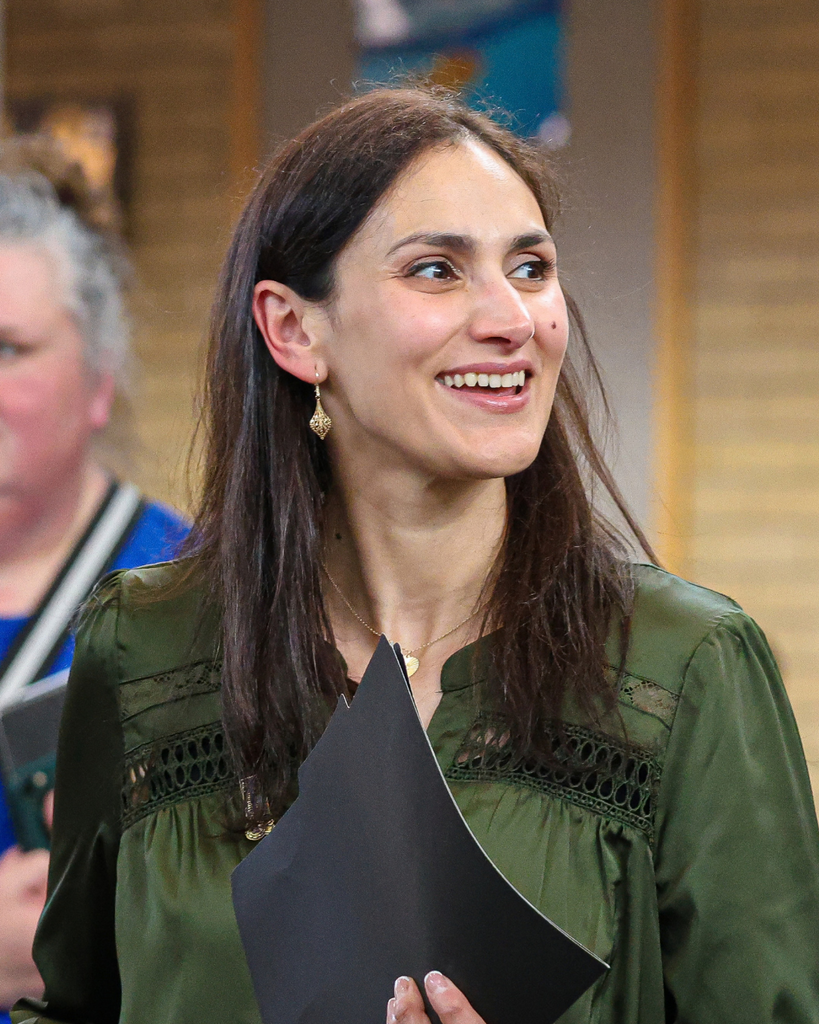 An adult walking and smiling. 