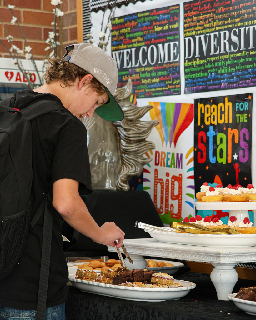 Students getting treats from a dessert table. 
