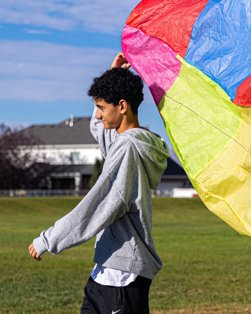 A student holding their hot air balloon above their head. 