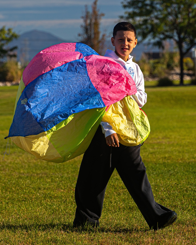 A student picks up their hot air balloon and starts walking. 