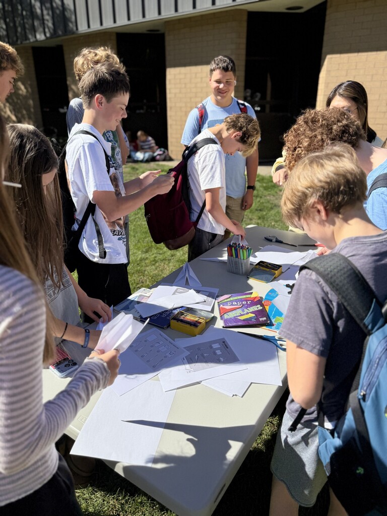 Students creating paper airplanes.